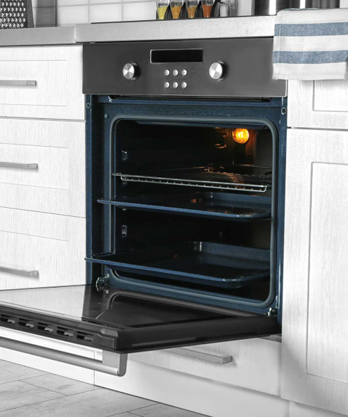 Four parfaitement nettoyé et ouvert dans une cuisine lumineuse