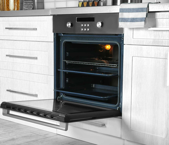 Four parfaitement nettoyé et ouvert dans une cuisine lumineuse