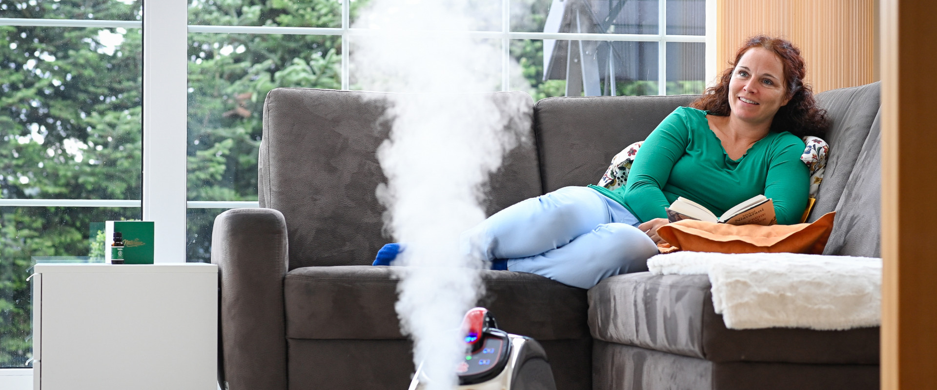 Une femme profite d'un climat ambiant parfait en lisant grâce à l'évaporateur Thermostar.